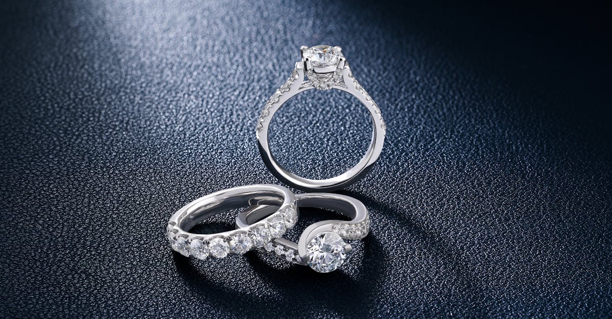 Close-up of luxurious diamond engagement and wedding rings on a textured surface, showcasing elegance and craftsmanship.