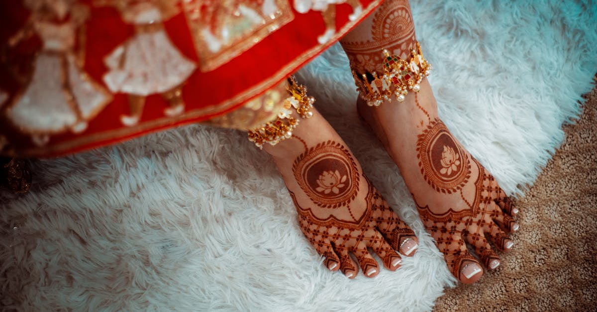 Detailed henna on feet with traditional anklets on a soft carpet, showcasing cultural elegance.
